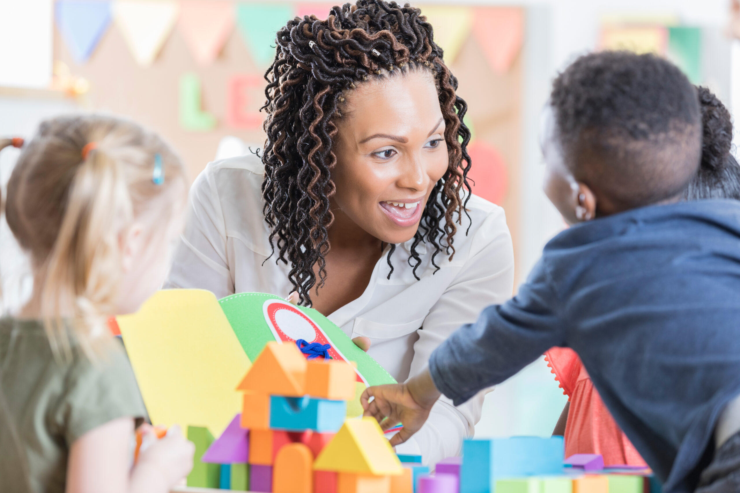 Una simpática maestra disfruta jugando con sus alumnos de preescolar